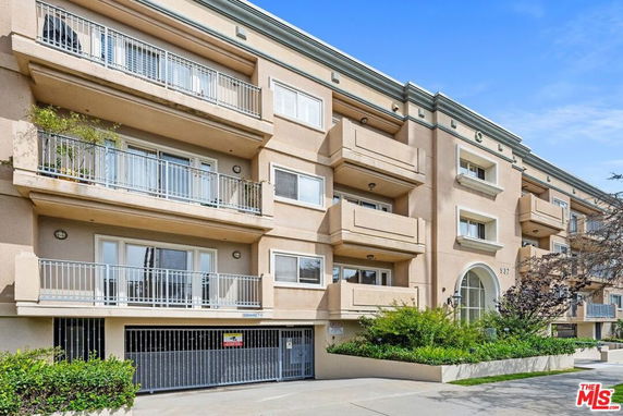 Front view of a multi-story apartment building with balconies.
