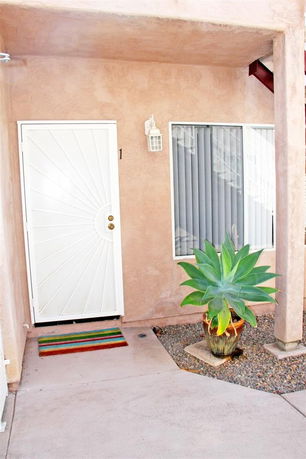 Front view of a building entrance with a white door and window.
