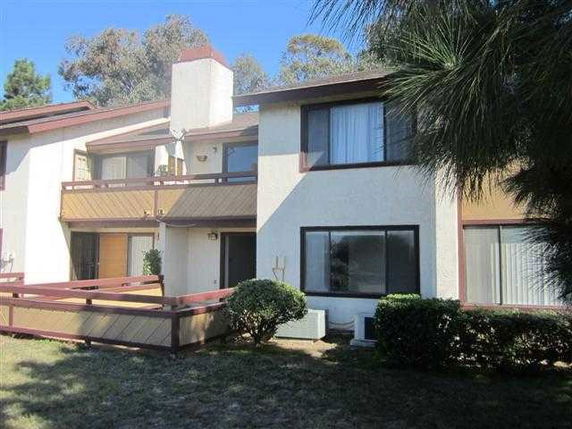 Front view of a two-story house with balconies and large windows.