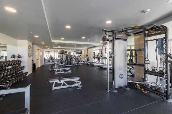 Interior view of a gym with various fitness equipment and free weights.