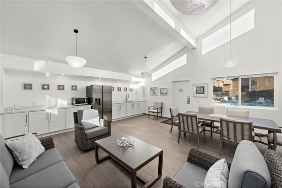 Interior view of a clubhouse with seating area, dining table, and kitchenette.