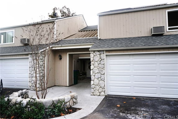 Front view of a two-story house with a double garage and stone facade.
