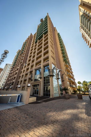 Front view of a tall apartment building with multiple balconies.
