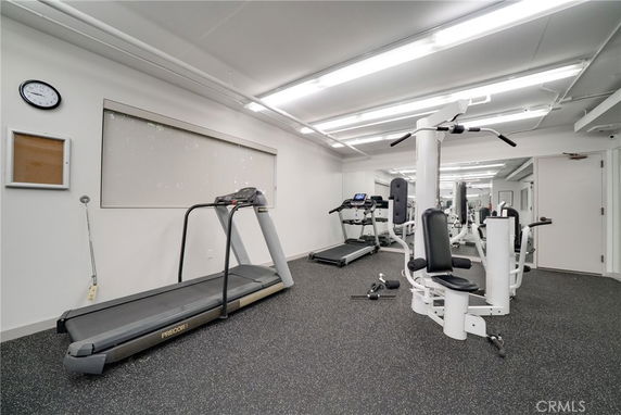 Indoor gym area with exercise equipment including a treadmill and weight machine.