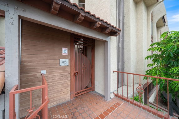 Entrance view of a building with a gated door and tiled floor.