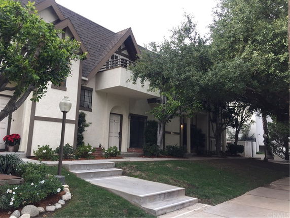 Front view of a multi-story house with a sloped roof and entrance steps.