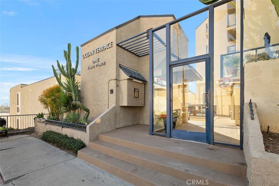 Front view of a building entrance with glass door and address signage.