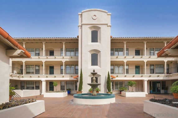 Front view of a multi-story building with a courtyard fountain.