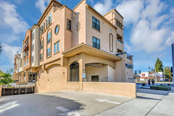 Front view of a multi-story building with arched entrances and decorative windows.