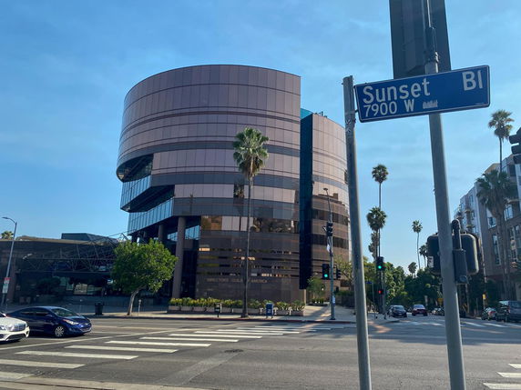 Front view of a modern multi-story building with glass facade.