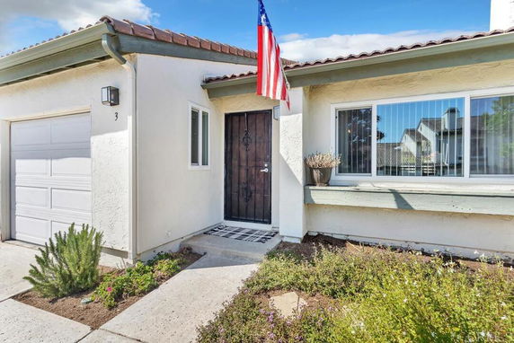 Front view of a single-story house with an American flag and a garage.