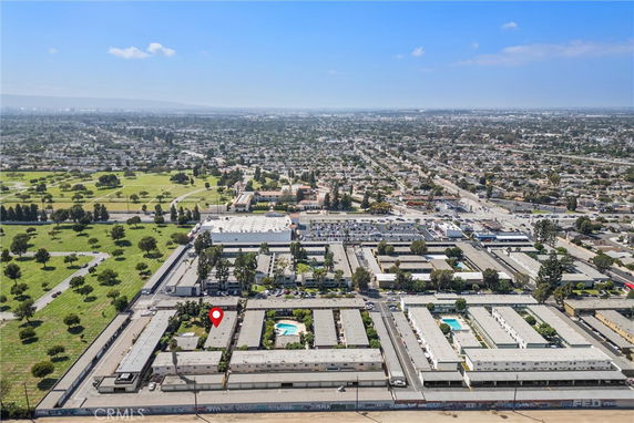 Aerial view of a residential complex with multiple buildings and swimming pools.
