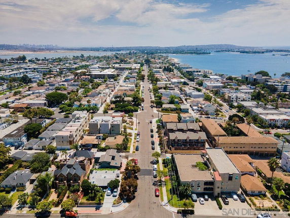 Aerial panoramic view of residential neighborhood near a body of water.
