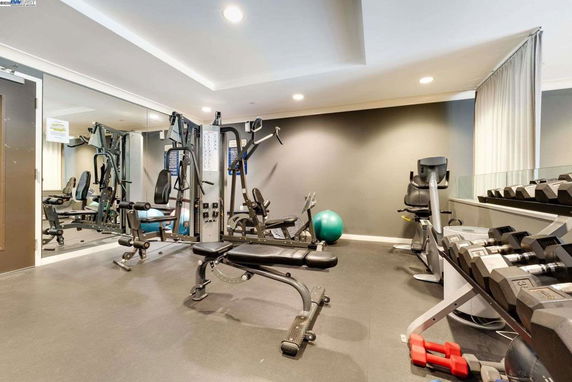 Indoor gym area with various exercise equipment including weights and benches.