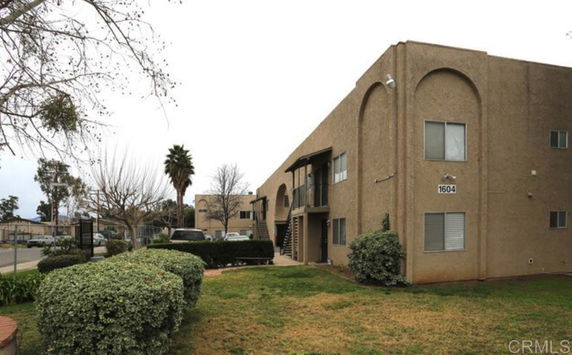 Exterior view of a two-story apartment building with arched architectural features.