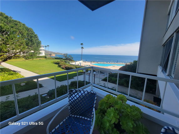 View from a building balcony overlooking the ocean and surrounding landscape.