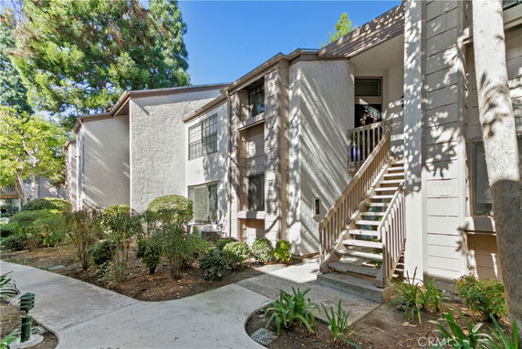 Front view of a multi-story residential building with exterior stairs.