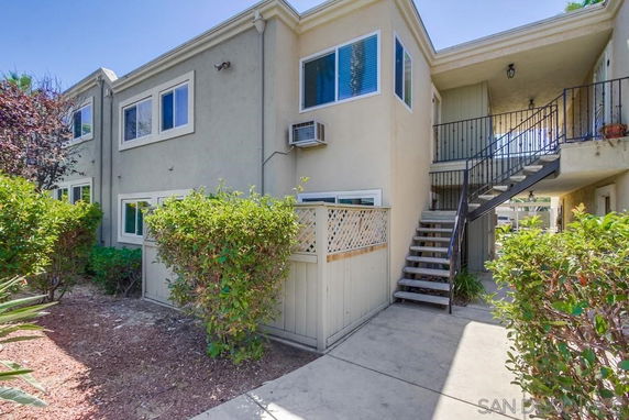 Front view of a two-story residential building with external staircase.