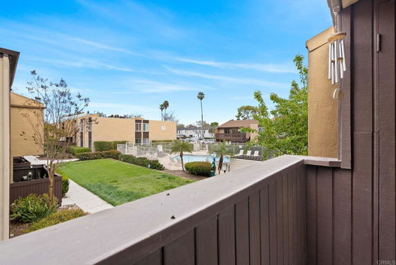 View of residential buildings and swimming pool area from a balcony.