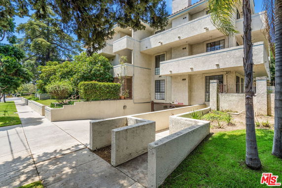 Front view of a multi-story apartment building with balconies.