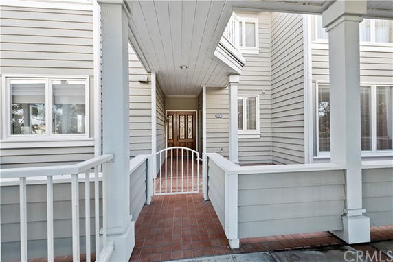 Front view of a house entrance with a porch and decorative railing.