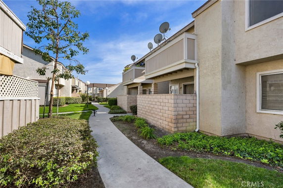 View of a residential building with exterior pathways and landscaped surroundings.