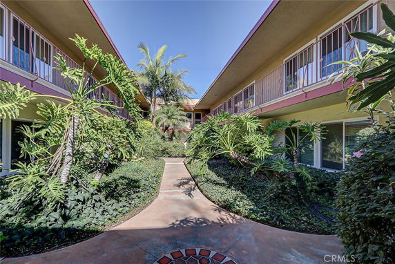 Front view of a two-story building with greenery in the courtyard.