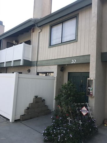 Front view of a two-story house with a fenced entrance.