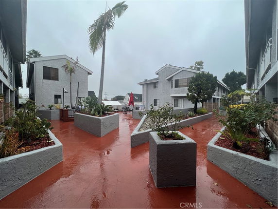 Front view of multi-story residential buildings with a walkway and planters.