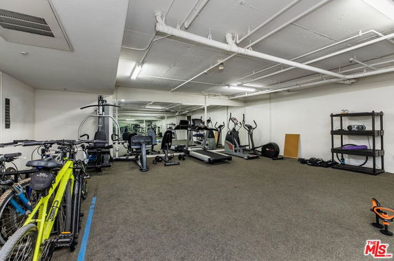 Indoor gym area with exercise equipment and bicycles.