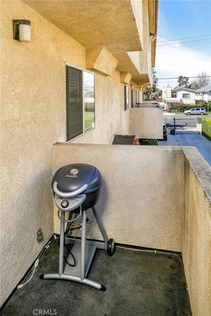 View from a building balcony showing exterior walls and nearby street and houses.