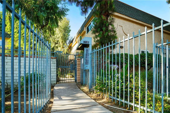 Front view of a multi-story building with a gated entrance.