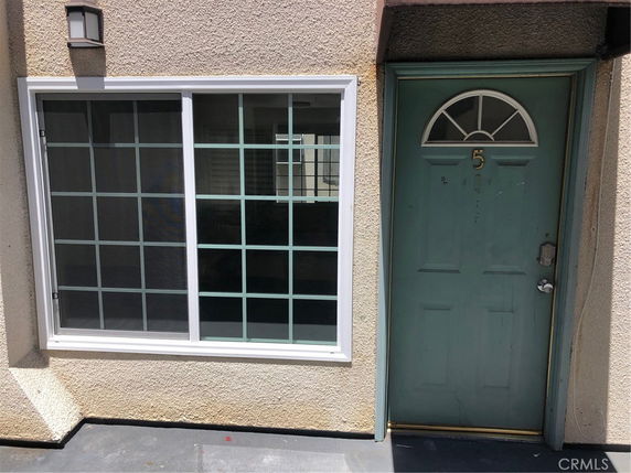 Front view of a residential entrance with a green door and large window.
