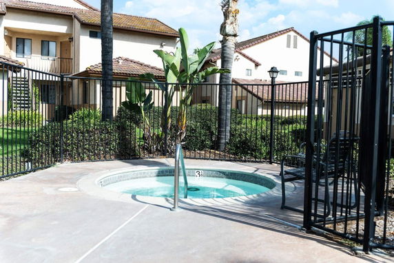 Small outdoor swimming pool area with a surrounding fence in a residential complex.