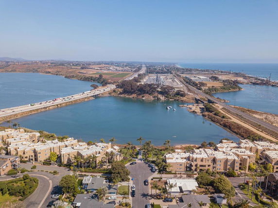 Aerial view of a coastal area with buildings and a bridge over a body of water.