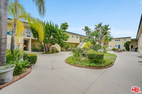Front view of a two-story apartment building with central courtyard and landscaping.