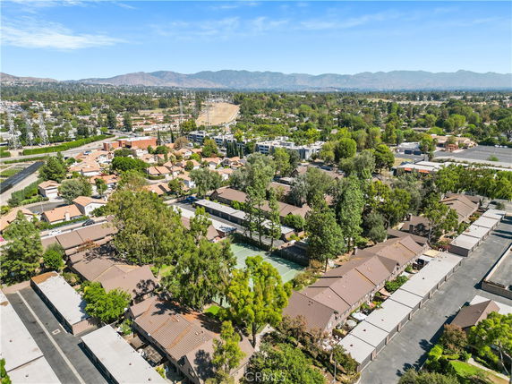 Aerial view of a residential neighborhood with surrounding areas and mountains in the background.