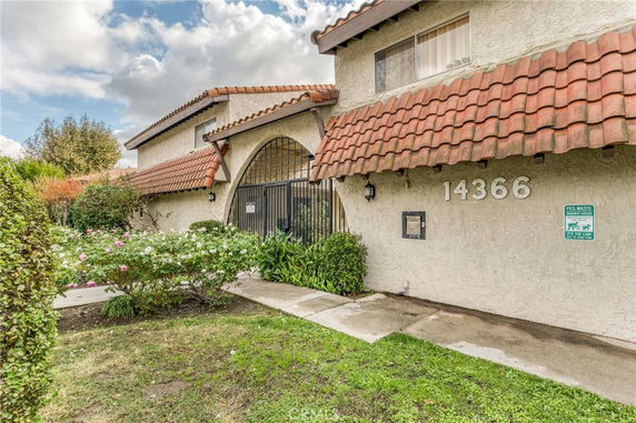 Front view of a house with an archway entrance and tile roof.