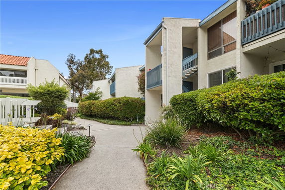 Front view of a two-story residential building with balconies and landscaped garden.