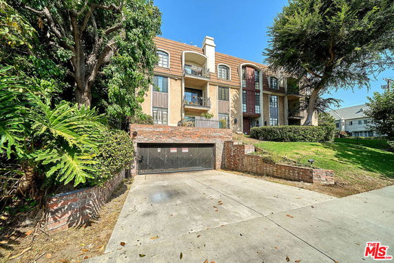 Front view of a multi-story building with balconies and brick detailing.
