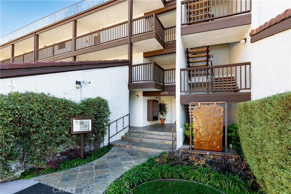 Front view of a multi-story building with balconies and entrances.