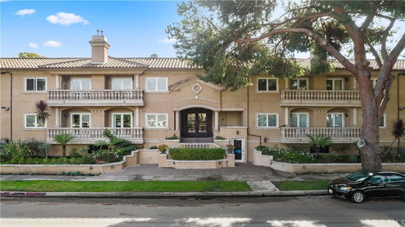 Front view of a two-story residential building with balconies and a central entrance.