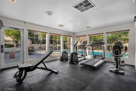 Indoor gym area with exercise equipment and large windows.