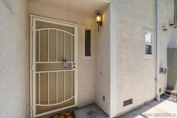 Front view of a house entrance with a metal security door and exterior light.
