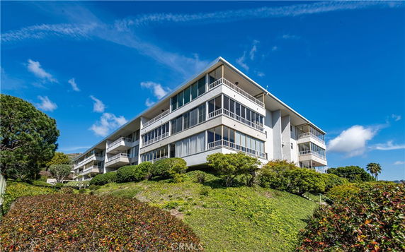 Front view of a multi-story residential building on a hillside.