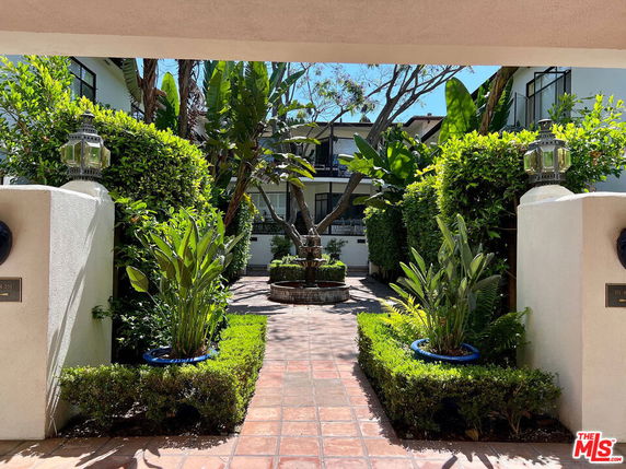 Front view of a two-story building with a courtyard and garden.