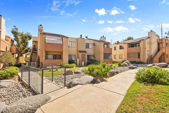 Front view of an apartment complex with multiple units and exterior stairs.