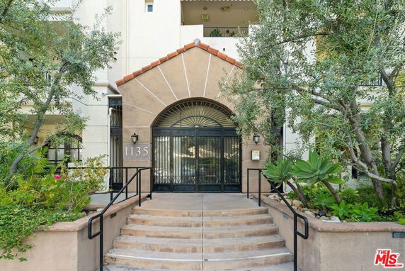 Front view of a building entrance with an archway and steps.