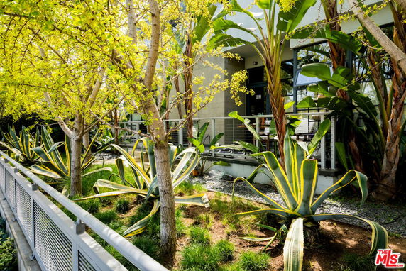 Front view of a building with large windows and a surrounding garden area.
