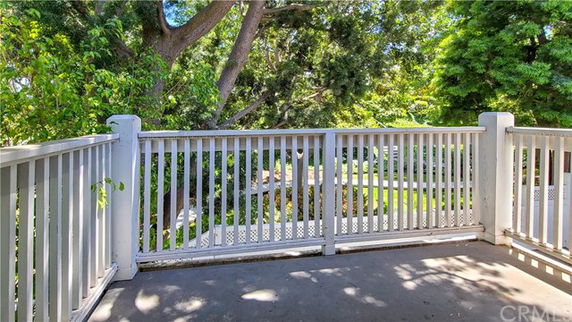 View from a balcony looking out at surrounding greenery and trees.